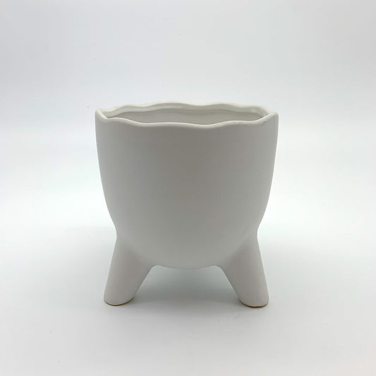 The Easy Breezy white ceramic planter featuring a wavy scalloped rim and three rounded legs, photographed on a clean gradient background.
