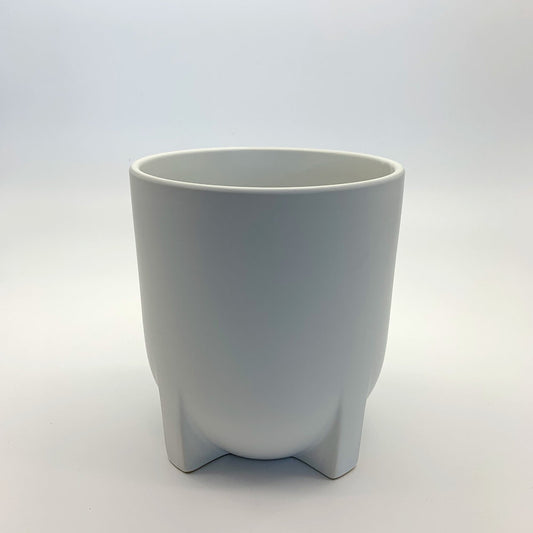 The Easy Keeper white satin-matte ceramic planter featuring short, squat legs and a smooth rounded shape, photographed on a clean gradient background.