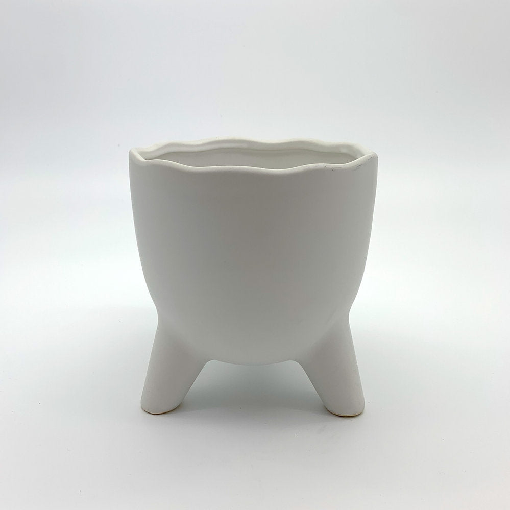 The Easy Breezy white ceramic planter featuring a wavy scalloped rim and three rounded legs, photographed on a clean gradient background.