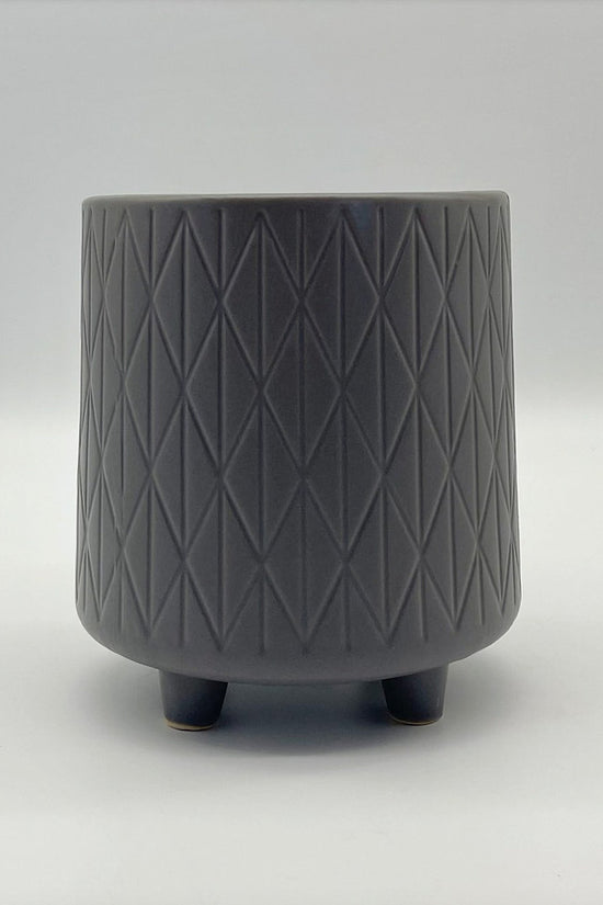 The Easygoing One grey ceramic planter with geometric texture and small feet, shown on a neutral background.