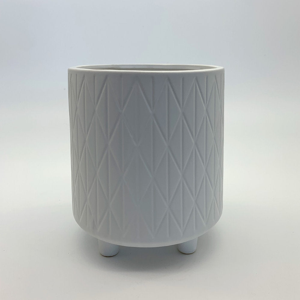 The Easygoing One white ceramic planter featuring a soft geometric pattern and small rounded feet, photographed on a clean gradient background.