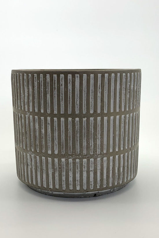 The Fresh Face textured cement planter with vertical line detailing, photographed on a clean gradient background.