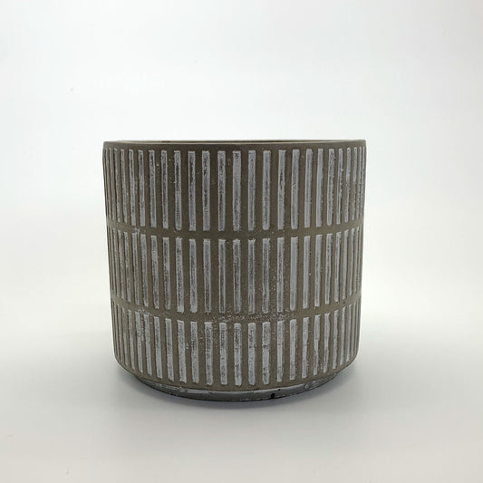The Fresh Face textured cement planter with vertical line detailing, photographed on a clean gradient background.