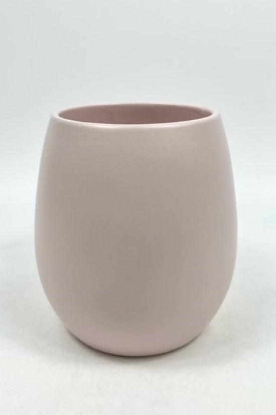 The Friendly Face pale pink matte planter with a rounded, minimalist form photographed on a white backdrop.
