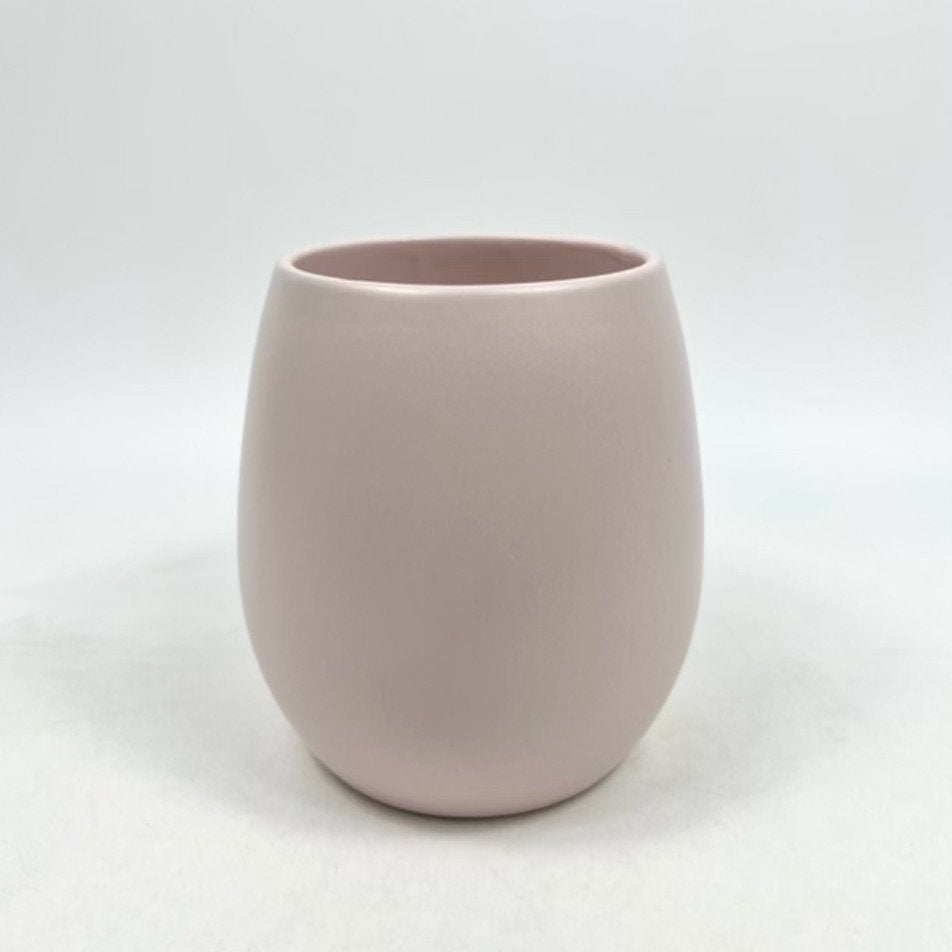 The Friendly Face pale pink matte planter with a rounded, minimalist form photographed on a white backdrop.