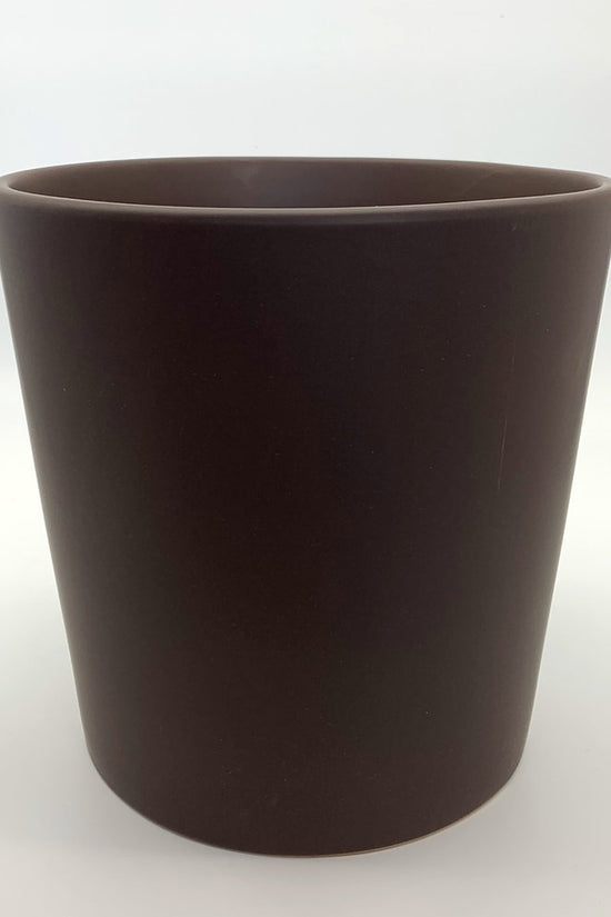 The Glow Getter chocolate brown glazed ceramic planter with a modern rounded shape, shown on a neutral white backdrop.