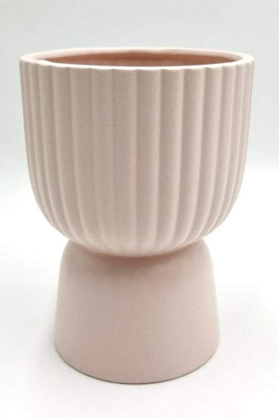 The Good Egg pale pink ribbed ceramic planter with a pedestal base, shown against a white backdrop.