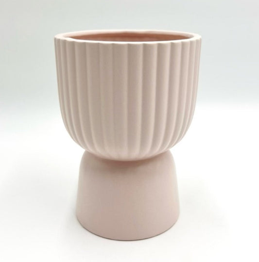 The Good Egg pale pink ribbed ceramic planter with a pedestal base, shown against a white backdrop.
