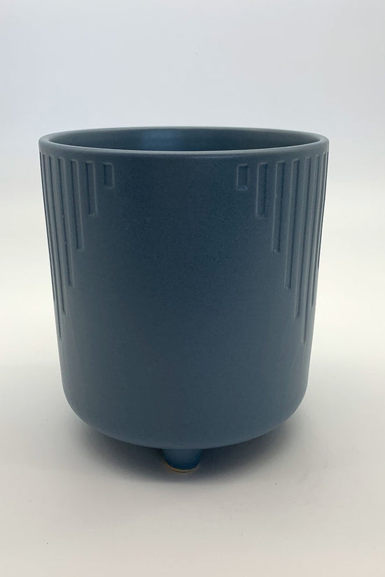 The Overachiever steel blue ribbed planter with a matte finish and elevated base, photographed on a clean white background.