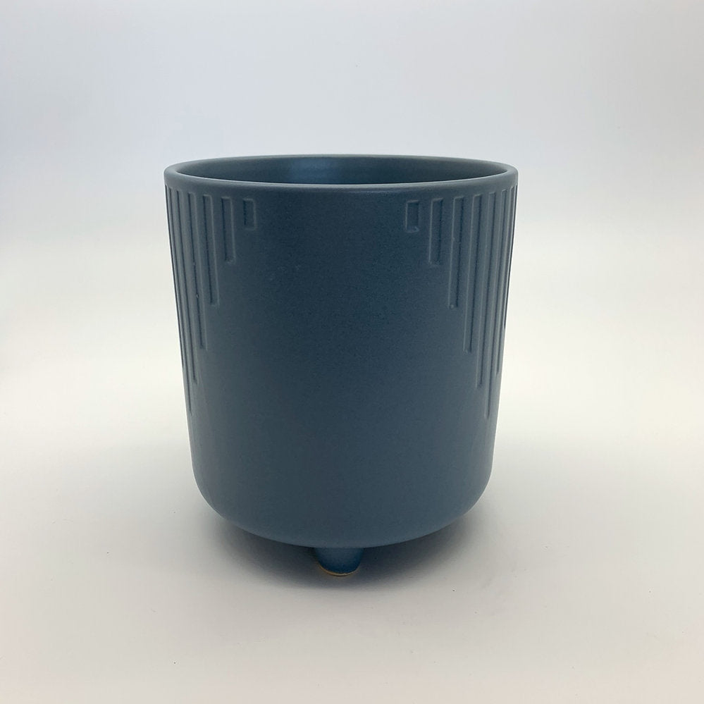 The Overachiever steel blue ribbed planter with a matte finish and elevated base, photographed on a clean white background.
