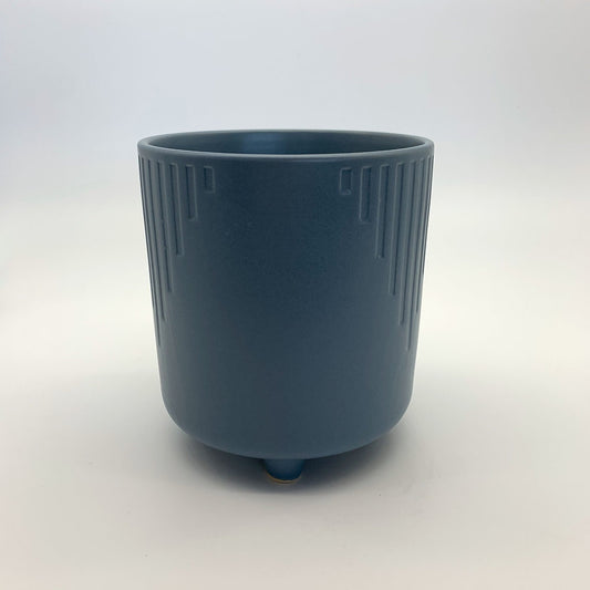 The Overachiever steel blue ribbed planter with a matte finish and elevated base, photographed on a clean white background.
