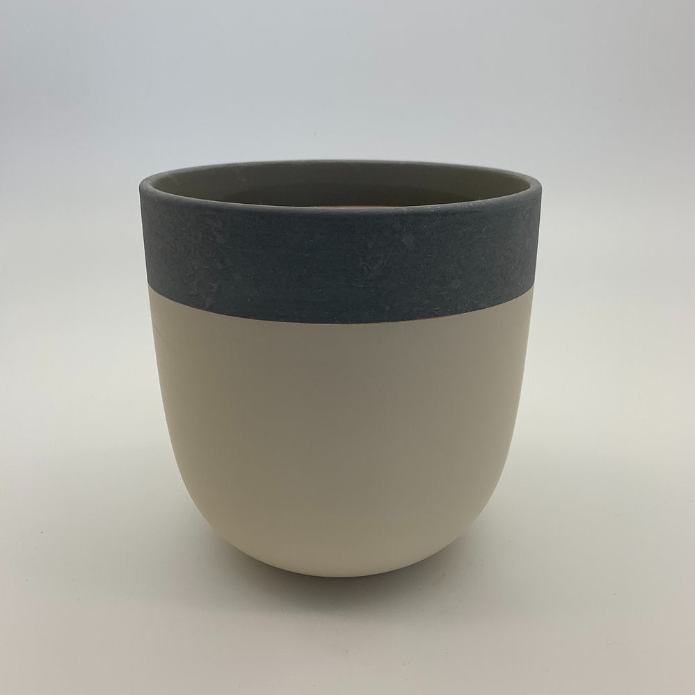 The Quiet One two-tone planter featuring a charcoal top band and light beige base, photographed on a clean white background.