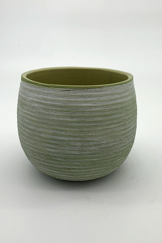 The Sidekick avocado green planter with matte finish and rounded shape photographed on a white surface.