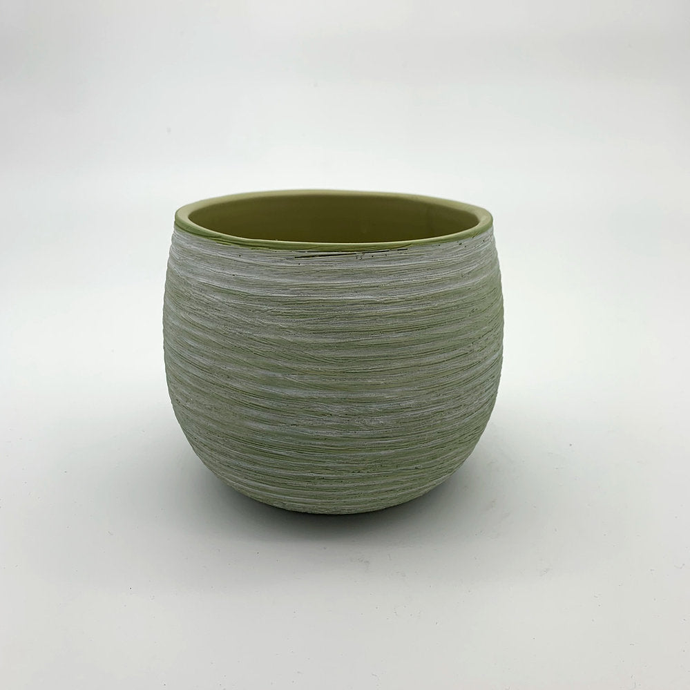 The Sidekick avocado green planter with matte finish and rounded shape photographed on a white surface.