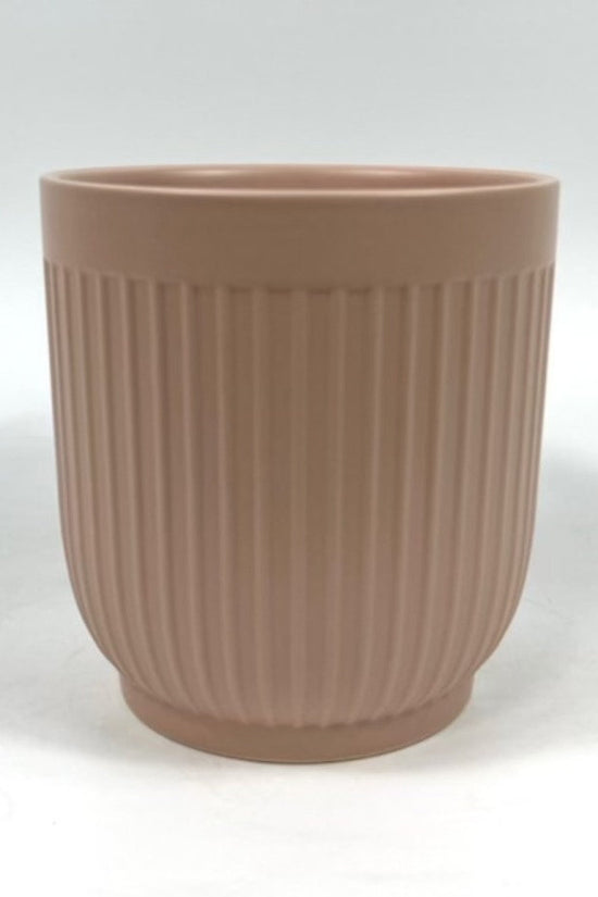 The Soft Shape planter in apricot with vertical ribbing photographed on a clean white background.