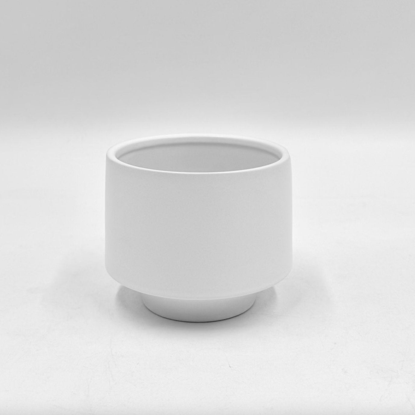 The Soft Spoken matte white planter with raised base and smooth finish photographed against a clean white background.