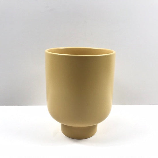 The Sunday Pot in mustard yellow with a raised pedestal shape and matte texture photographed on white.