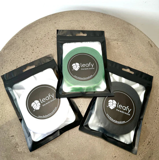 Three packages of 'leafy' on a textured surface