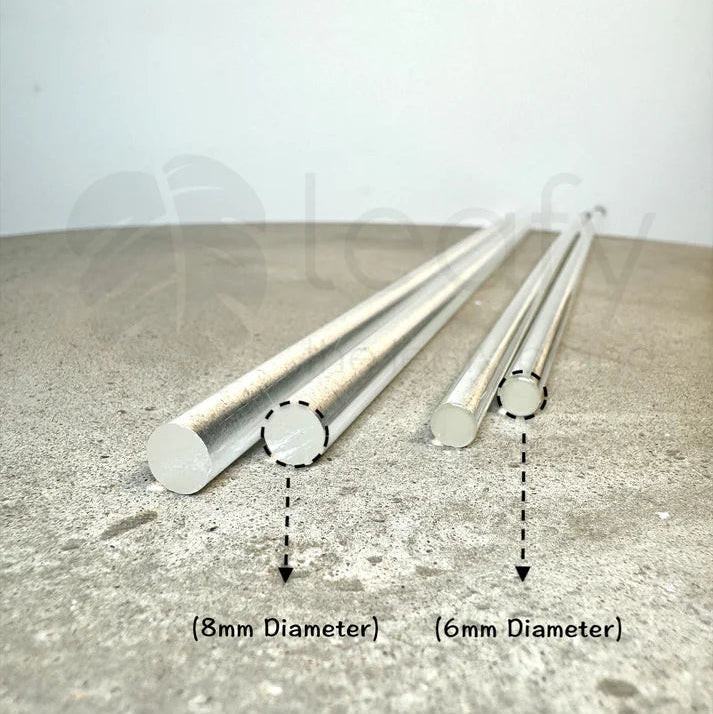 four acrylic rods with labelled diameters on a concrete surface